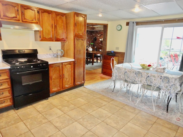 409 N Main St, Winchester, CT 06098 - kitchen with black range with gas cooktop, extractor fan, light countertops, brown cabinetry, and a paneled ceiling