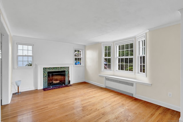 1815 Asylum Ave, West Hartford, CT 06117 - unfurnished living room featuring radiator heating unit, a fireplace with flush hearth, wood finished floors, and ornamental molding
