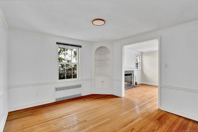 1815 Asylum Ave, West Hartford, CT 06117 - empty room featuring radiator, wood finished floors, built in features, a fireplace with flush hearth, and crown molding