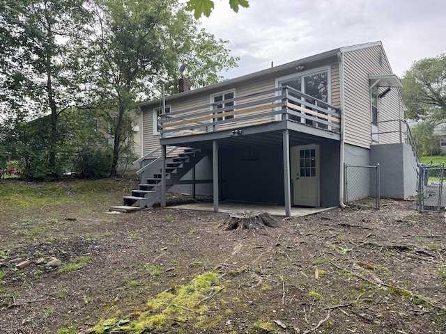 256 Alexander Rd, New Britain, CT 06053 - back of house featuring stairway, a wooden deck, a gate, a chimney, and a patio