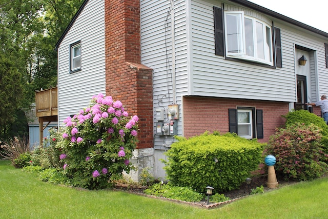 243 Courtland Ave, Waterbury, CT 06705 - view of side of home with a chimney, a yard, and brick siding