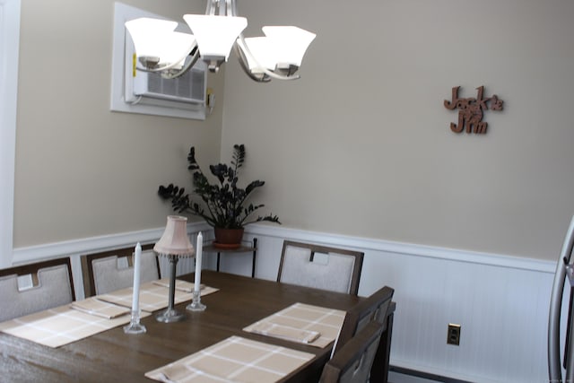 243 Courtland Ave, Waterbury, CT 06705 - dining space with a wainscoted wall, a chandelier, a decorative wall, cooling unit, and a baseboard heating unit
