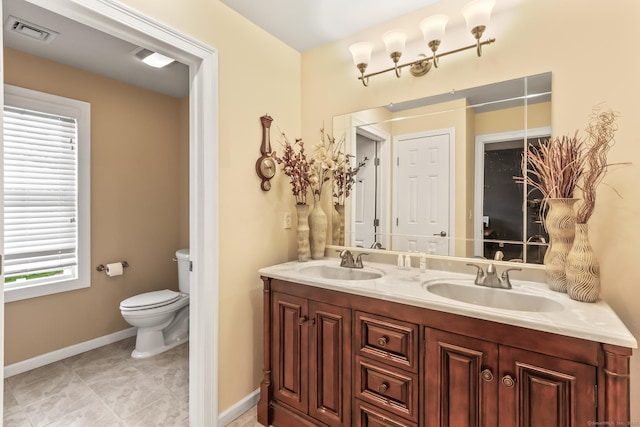 74 Avery Ave, Meriden, CT 06450 - bathroom featuring toilet, double vanity, and baseboards