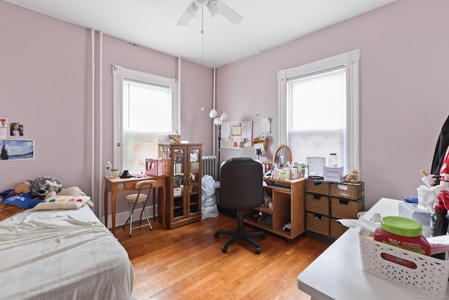 30 Newton St, Hartford, CT 06106 - bedroom featuring radiator heating unit, multiple windows, wood finished floors, and an office area