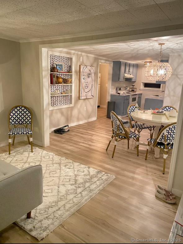 2 Dilliston Rd, Barkhamsted, CT 06063 - dining room featuring light wood-style floors, baseboards, crown molding, and a chandelier