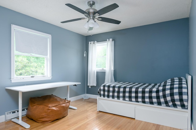 104 E St, Hebron, CT 06248 - bedroom with wood finished floors, a baseboard heating unit, baseboards, and a ceiling fan