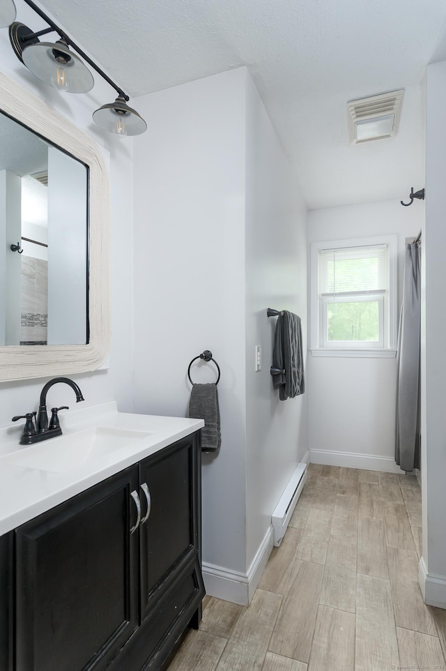 104 E St, Hebron, CT 06248 - bathroom featuring a baseboard radiator, vanity, wood finished floors, curtained shower, and baseboards