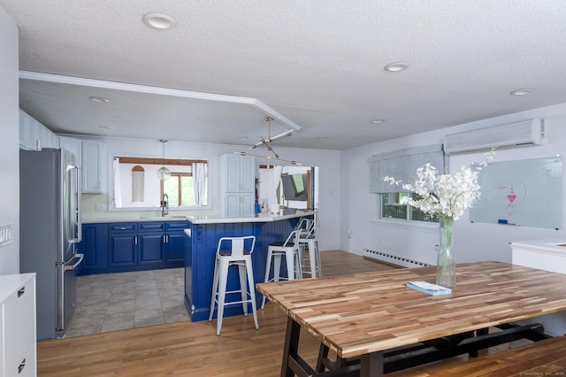 104 E St, Hebron, CT 06248 - dining area with a wall mounted air conditioner, a textured ceiling, baseboard heating, light wood finished floors, and recessed lighting