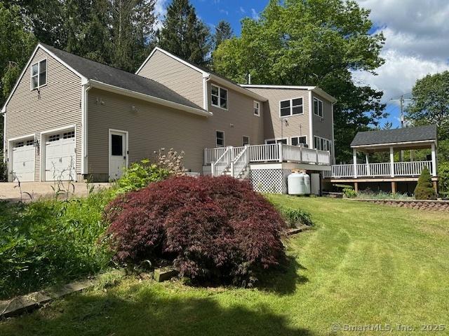 149 Mill Hill Rd, Colchester, CT 06415 - back of house featuring a deck, a yard, an attached garage, and concrete driveway