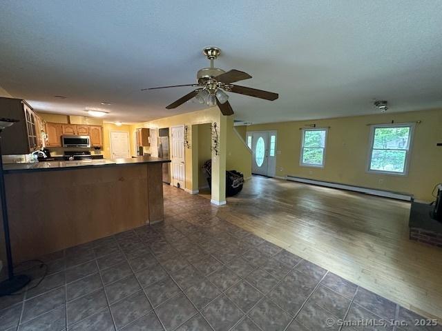 149 Mill Hill Rd, Colchester, CT 06415 - kitchen featuring stainless steel microwave, a baseboard heating unit, a peninsula, open floor plan, and a ceiling fan