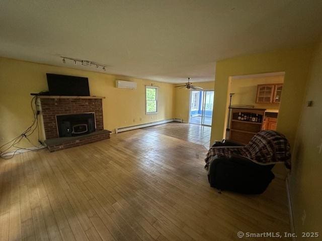 149 Mill Hill Rd, Colchester, CT 06415 - living room featuring baseboard heating, an AC wall unit, hardwood / wood-style flooring, and track lighting