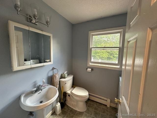 149 Mill Hill Rd, Colchester, CT 06415 - bathroom featuring baseboard heating, a sink, a textured ceiling, toilet, and tile patterned floors