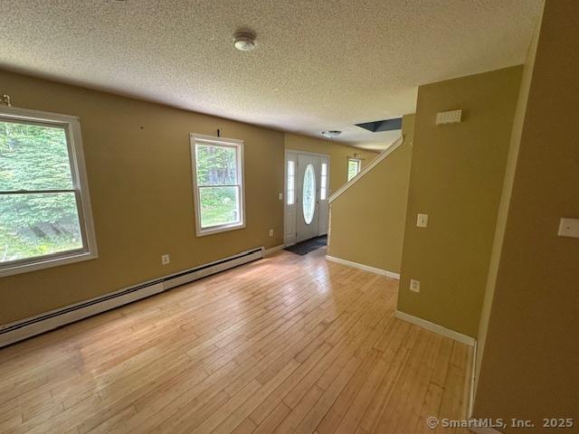 149 Mill Hill Rd, Colchester, CT 06415 - spare room featuring a textured ceiling, a baseboard radiator, light wood-style flooring, and baseboards