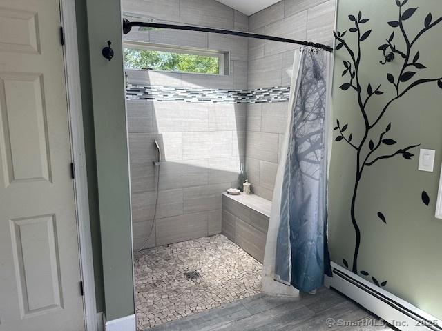 149 Mill Hill Rd, Colchester, CT 06415 - bathroom featuring a baseboard heating unit, a shower stall, and wood finished floors