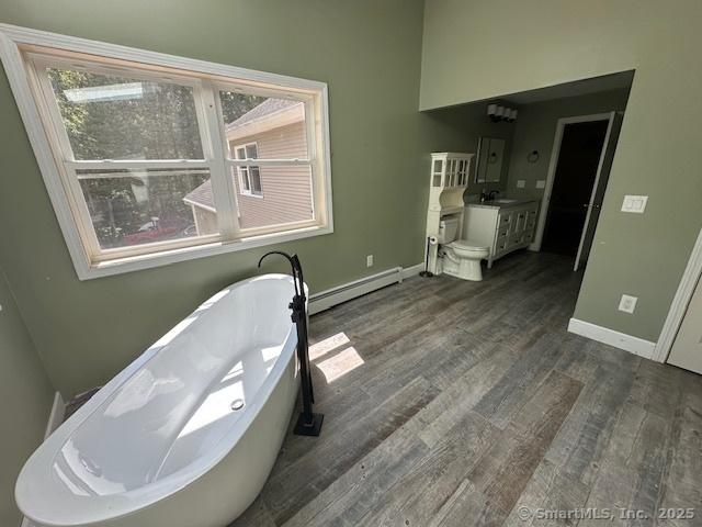 149 Mill Hill Rd, Colchester, CT 06415 - full bathroom featuring a baseboard heating unit, a soaking tub, vanity, wood finished floors, and baseboards