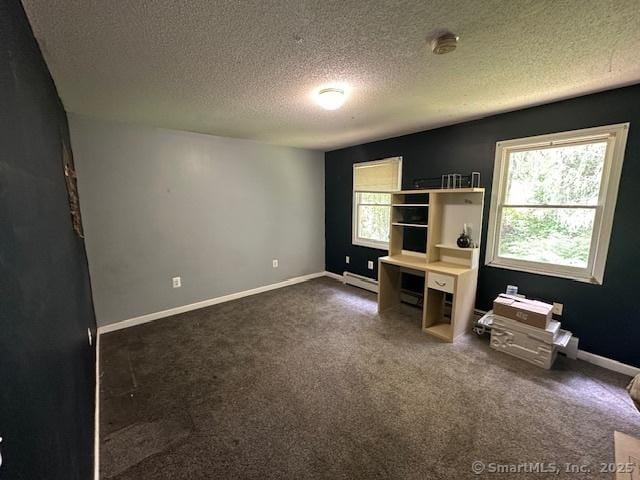 149 Mill Hill Rd, Colchester, CT 06415 - unfurnished bedroom featuring a baseboard radiator, a textured ceiling, dark colored carpet, and baseboards