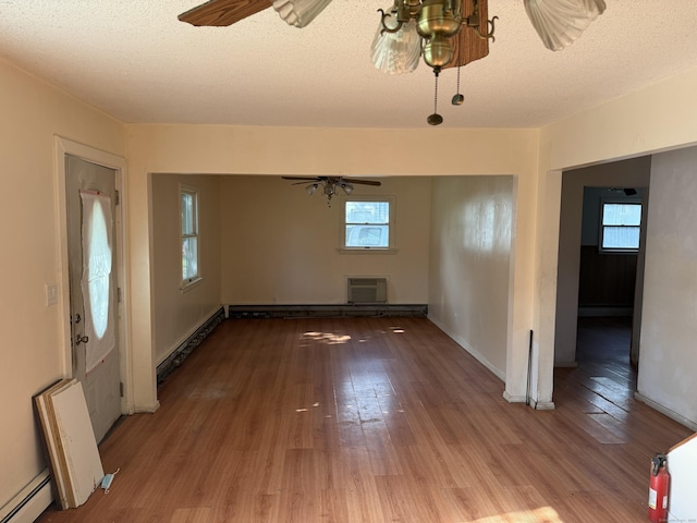 81 Melrose Dr, New Haven, CT 06513 - empty room featuring baseboard heating, a baseboard heating unit, wood finished floors, plenty of natural light, and a textured ceiling