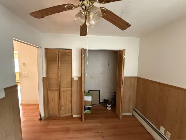 81 Melrose Dr, New Haven, CT 06513 - corridor featuring light wood finished floors, a baseboard radiator, wainscoting, and wood walls