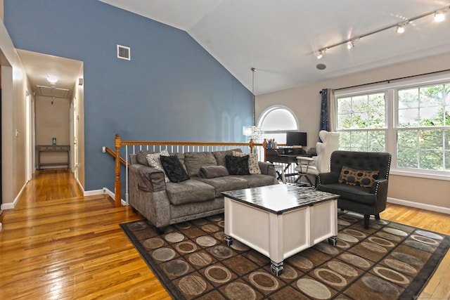 354 Lynne Pl, Bridgeport, CT 06610 - living room featuring attic access, vaulted ceiling, hardwood / wood-style floors, rail lighting, and baseboards
