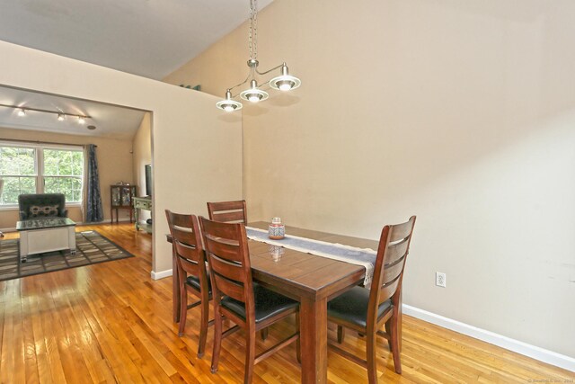 354 Lynne Pl, Bridgeport, CT 06610 - dining area featuring wood-type flooring, a chandelier, baseboards, and vaulted ceiling