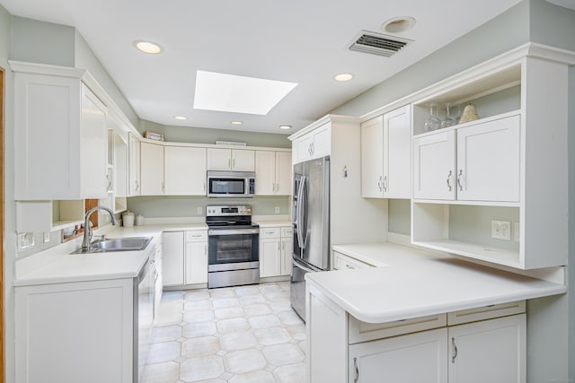 28 Sherry Ln, Danbury, CT 06811 - kitchen featuring stainless steel appliances, a sink, a skylight, open shelves, and a peninsula