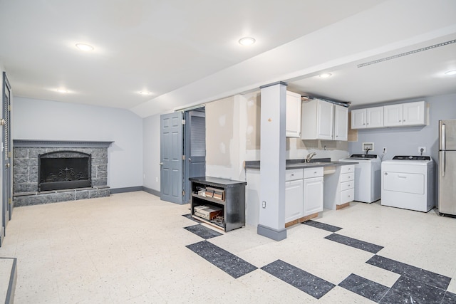 28 Sherry Ln, Danbury, CT 06811 - kitchen featuring white cabinets, freestanding refrigerator, washing machine and clothes dryer, light flooring, and a fireplace