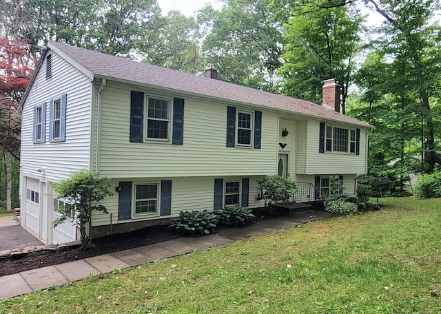 550 W Lake Ave, Guilford, CT 06437 - split foyer home featuring a chimney, a front lawn, an attached garage, and driveway
