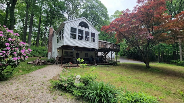 550 W Lake Ave, Guilford, CT 06437 - view of front of home featuring stairs, a wooden deck, a front yard, and a chimney