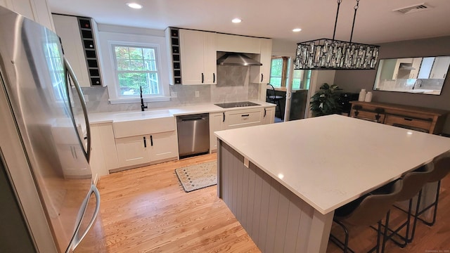 550 W Lake Ave, Guilford, CT 06437 - kitchen featuring stainless steel appliances, under cabinet range hood, light wood-style floors, white cabinetry, and recessed lighting