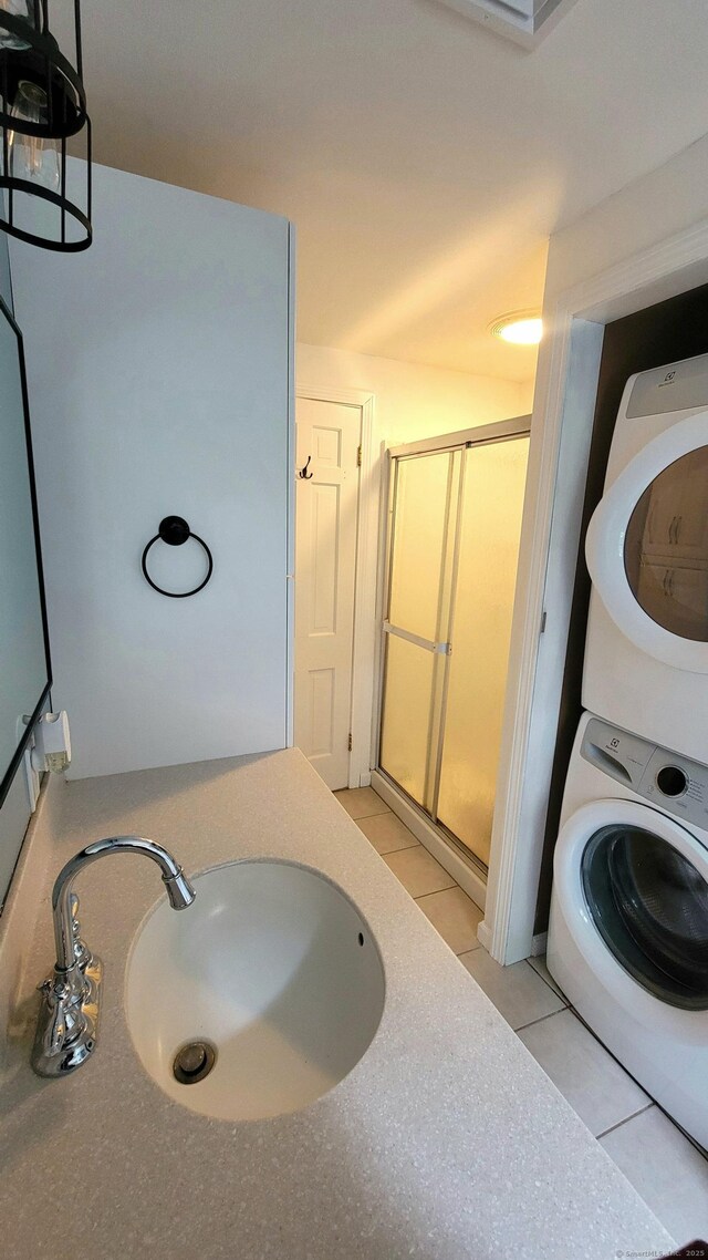 550 W Lake Ave, Guilford, CT 06437 - full bath with stacked washer and clothes dryer, a sink, a shower stall, and tile patterned floors