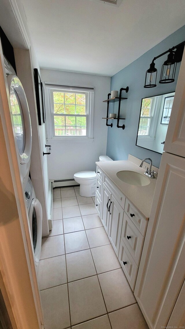 550 W Lake Ave, Guilford, CT 06437 - bathroom featuring stacked washing machine and dryer, baseboard heating, vanity, toilet, and tile patterned flooring