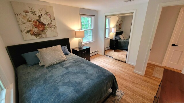 550 W Lake Ave, Guilford, CT 06437 - bedroom featuring a baseboard heating unit, light wood-style floors, a closet, and baseboards