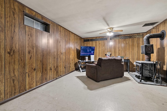 24 Ledgewood Ct, Norwich, CT 06360 - living area with a wood stove, wooden walls, ceiling fan, and tile patterned floors