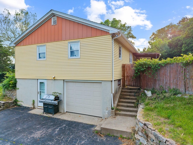 24 Ledgewood Ct, Norwich, CT 06360 - view of side of home featuring an attached garage and asphalt driveway