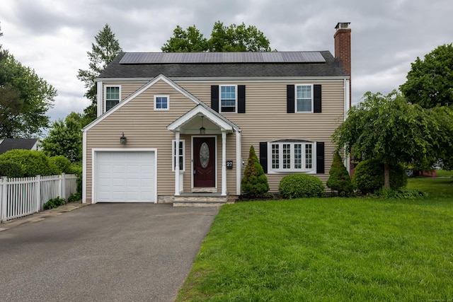 27 Judd Rd, Wethersfield, CT 06109 - view of front facade with a chimney, roof mounted solar panels, driveway, and a garage
