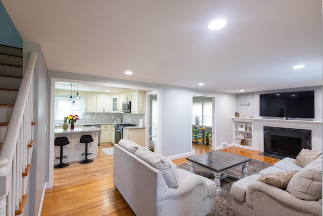 27 Judd Rd, Wethersfield, CT 06109 - living area featuring light wood-style flooring, stairs, recessed lighting, baseboards, and plenty of natural light