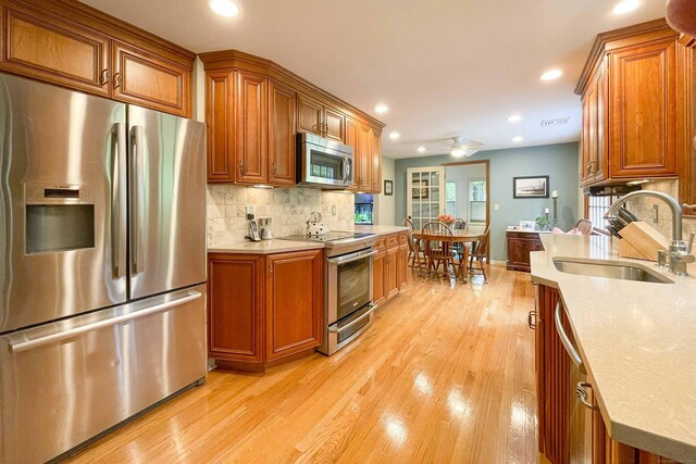 72 Cox Rd, Portland, CT 06480 - kitchen featuring stainless steel appliances, a sink, brown cabinets, light wood-style floors, and recessed lighting