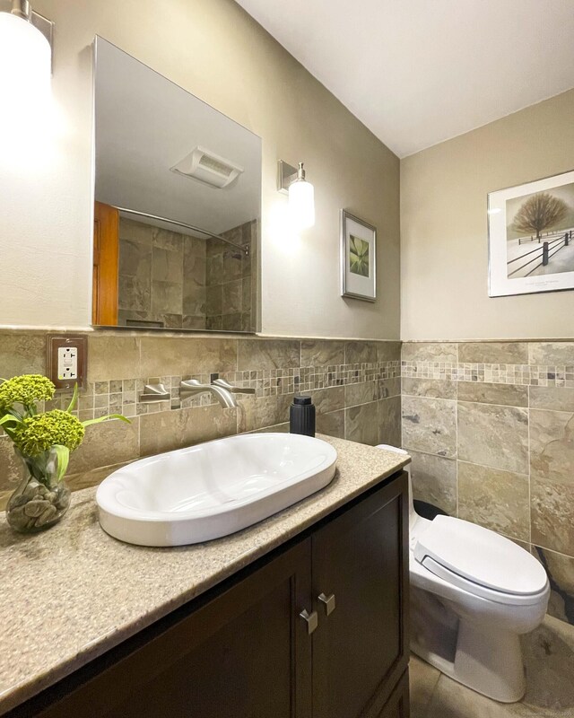 72 Cox Rd, Portland, CT 06480 - bathroom with tile walls, vanity, toilet, tiled shower, and tile patterned flooring
