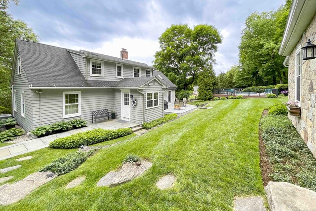 72 Cox Rd, Portland, CT 06480 - back of house featuring roof with shingles, a patio area, a chimney, and a yard