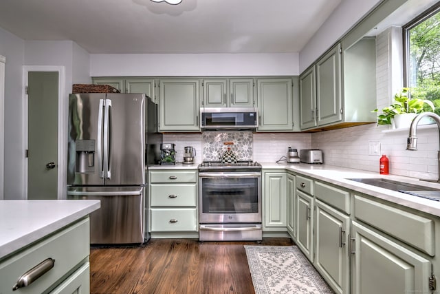 26 Freedman Ln, Monroe, CT 06468 - kitchen with appliances with stainless steel finishes, light countertops, decorative backsplash, dark wood finished floors, and a sink