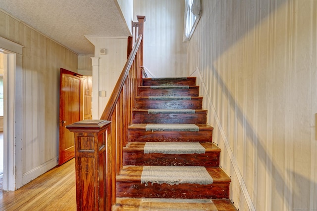 45 Perkins Ave, Norwich, CT 06360 - stairway featuring wood finished floors, a textured ceiling, crown molding, and wallpapered walls