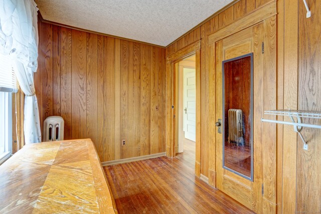 45 Perkins Ave, Norwich, CT 06360 - unfurnished office with wood walls, wood finished floors, baseboards, a textured ceiling, and crown molding