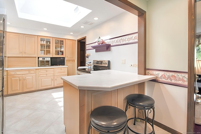 47 Delmont Rd, East Hartford, CT 06108 - kitchen with stainless steel range with electric stovetop, a peninsula, a kitchen breakfast bar, a skylight, and glass insert cabinets