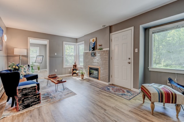 187 W Main St, East Lyme, CT 06357 - living room with wood finished floors, a fireplace, wainscoting, and a decorative wall
