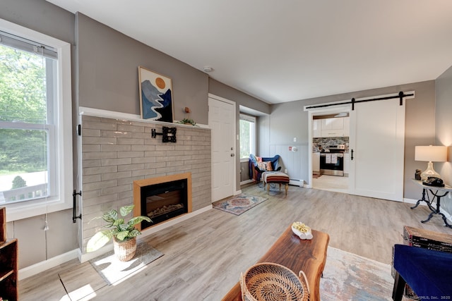 187 W Main St, East Lyme, CT 06357 - living room with wood finished floors, healthy amount of natural light, a fireplace, and a barn door