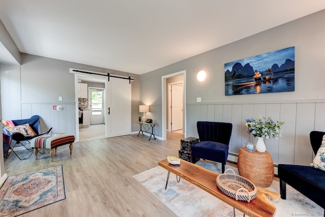 187 W Main St, East Lyme, CT 06357 - living area with a barn door, light wood-type flooring, wainscoting, and baseboard heating
