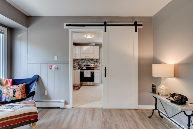 187 W Main St, East Lyme, CT 06357 - living area with a baseboard heating unit, light wood-style flooring, and a barn door
