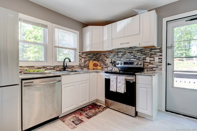 187 W Main St, East Lyme, CT 06357 - kitchen featuring appliances with stainless steel finishes, under cabinet range hood, a sink, and decorative backsplash
