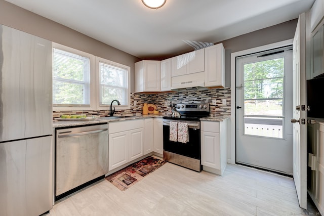 187 W Main St, East Lyme, CT 06357 - kitchen with stainless steel appliances, a sink, decorative backsplash, light stone counters, and under cabinet range hood