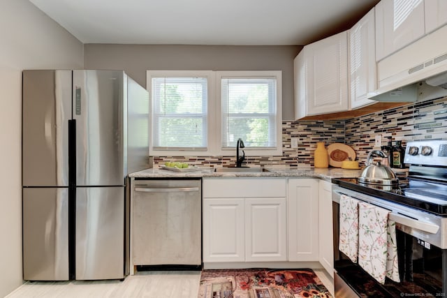187 W Main St, East Lyme, CT 06357 - kitchen with stainless steel appliances, white cabinetry, light stone counters, tasteful backsplash, and light wood-style floors